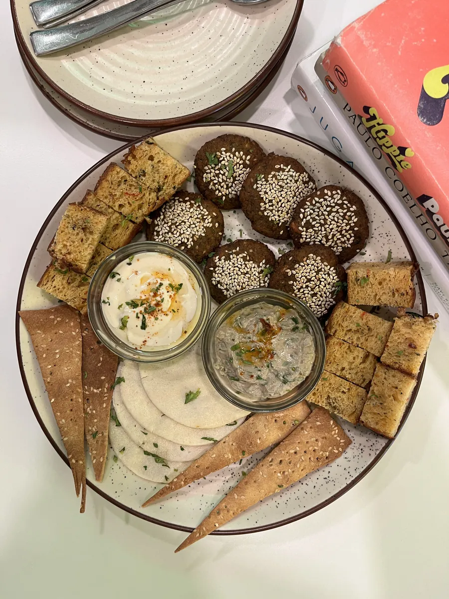 A breakfast platter of steamed savouries with three chutneys in small bowls
